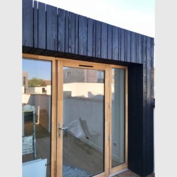 Du bois brûlé comme bardage pour l'extension