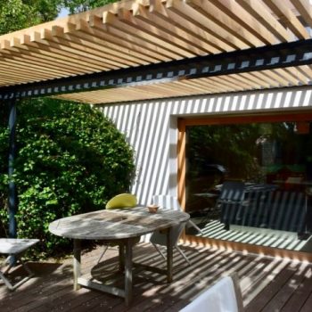 Une cuisine avec une grande baie vitrée et une large pergola